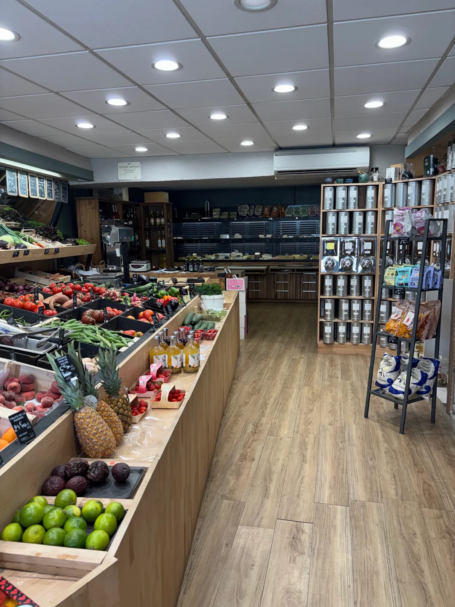 Intérieur de la boutique Au Jardin Fromager à Melesse : étals de fruits et légumes et rayons d'épicerie fine